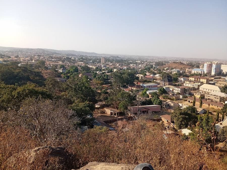 Hillside view over rooftops and open ground in Jos, Nigeria